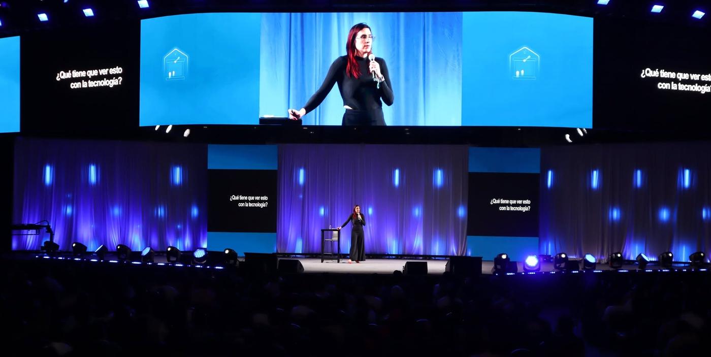 Ophelia Pastrana en un escenario de arena, proyectada en pantalla gigante junto a la pregunta: ¿Qué tiene que ver esto con la tecnología?