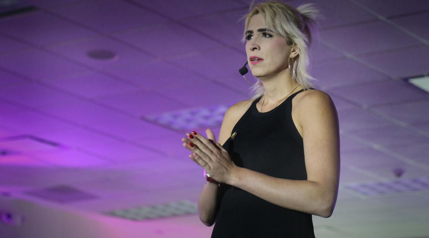 Ophelia Pastrana hablando en el escenario, con diadema de micrófono.