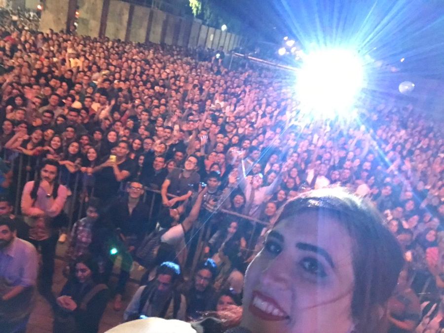 Selfie de Ophelia con un auditorio lleno detrás. Horizontal.