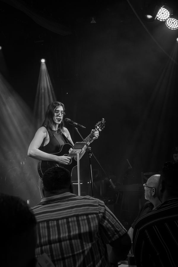 Ophelia con guitarra en el escenario de Lenchafest 2025, blanco y negro. Vertical.