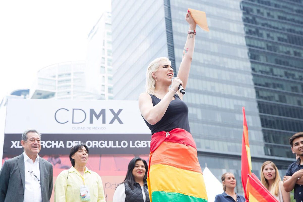 Ophelia con la bandera arcoíris inaugurando la Marcha LGBT 2018 en CDMX. Horizontal.