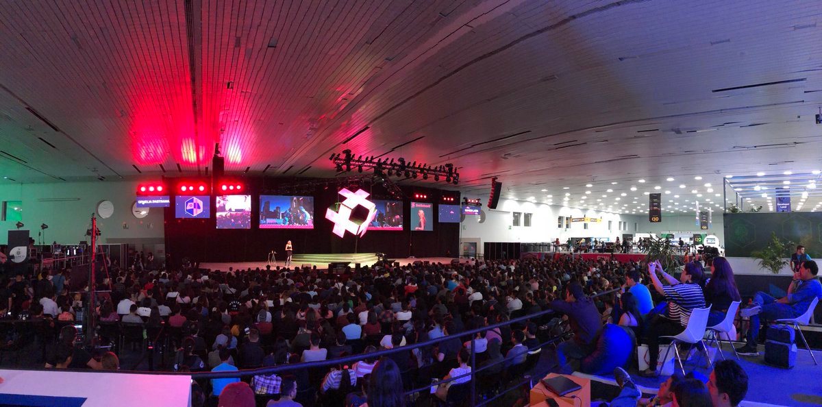 Panorámica de un recinto lleno con el escenario al fondo. Horizontal.